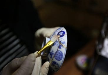 Broken pottery cup getting repaired